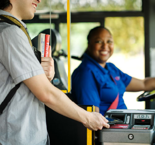a man pays as he boards the bus
