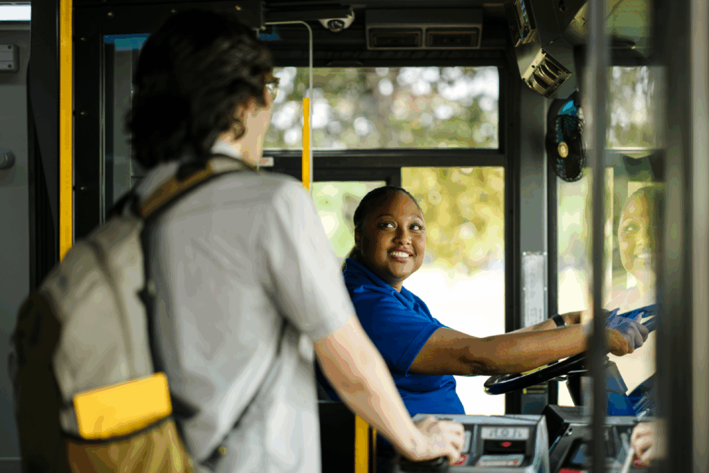 young man pays his fare as he boards a bus